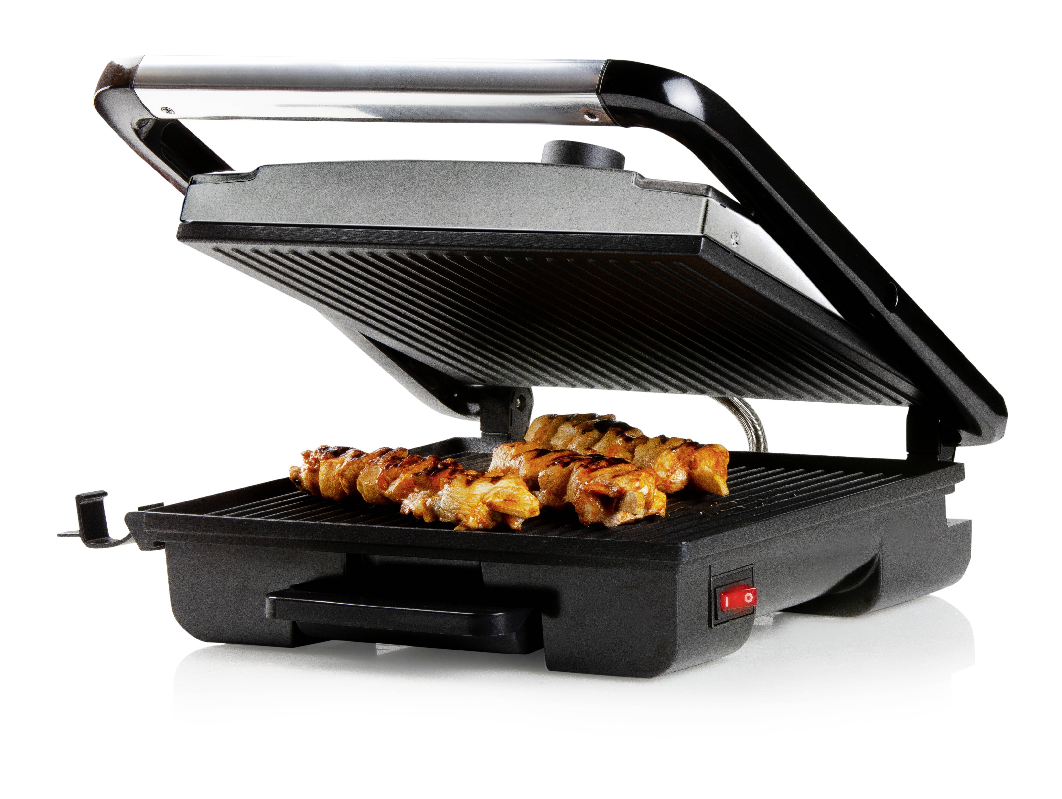 An electric tabletop grill with chicken pieces on the grilled surface, lid slightly open.