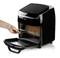 Compact hot air oven with the door open. A hand is pulling out the grill, suitable for oil-free frying.