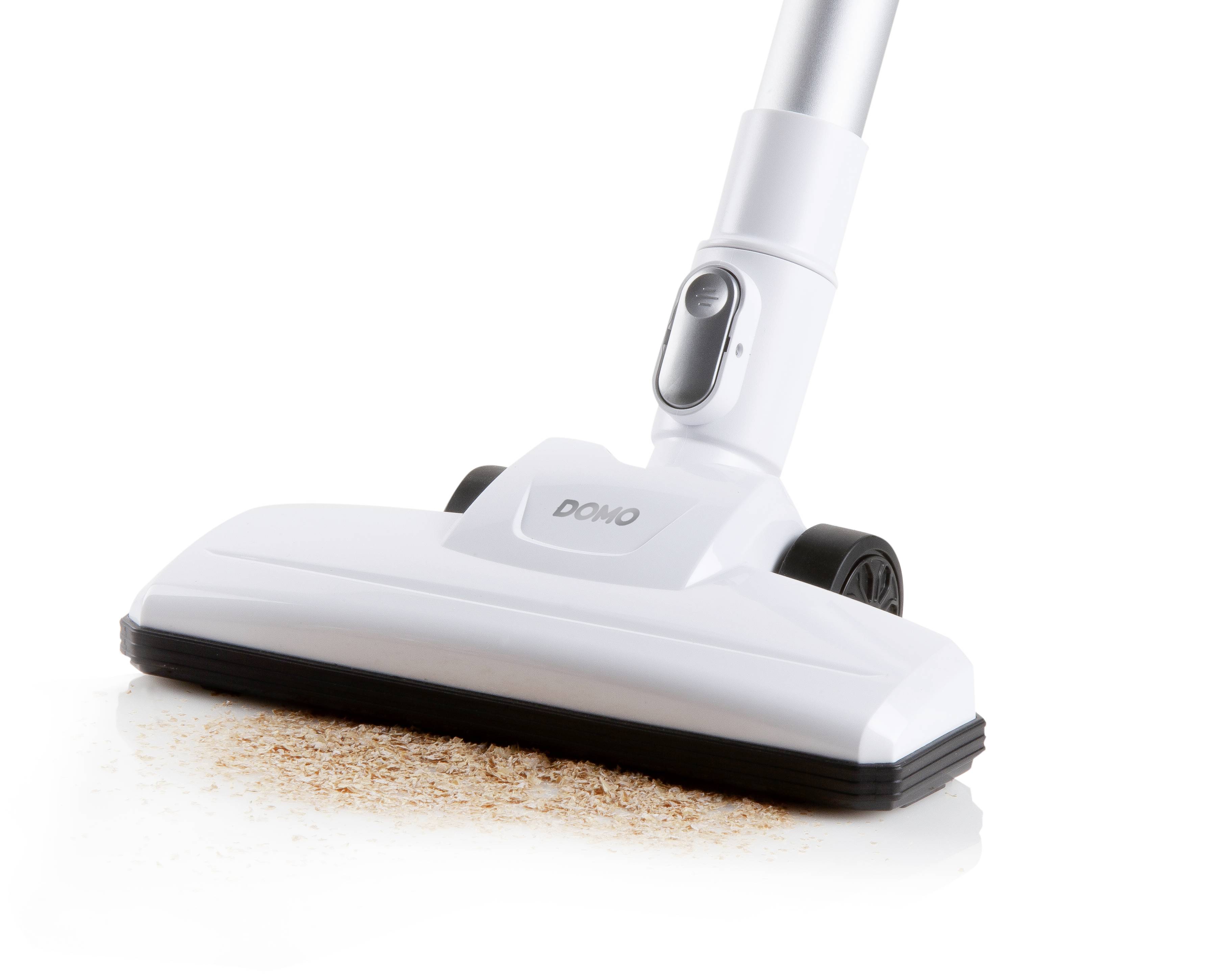 Vacuum cleaner nozzle sucks dirt from white floor.