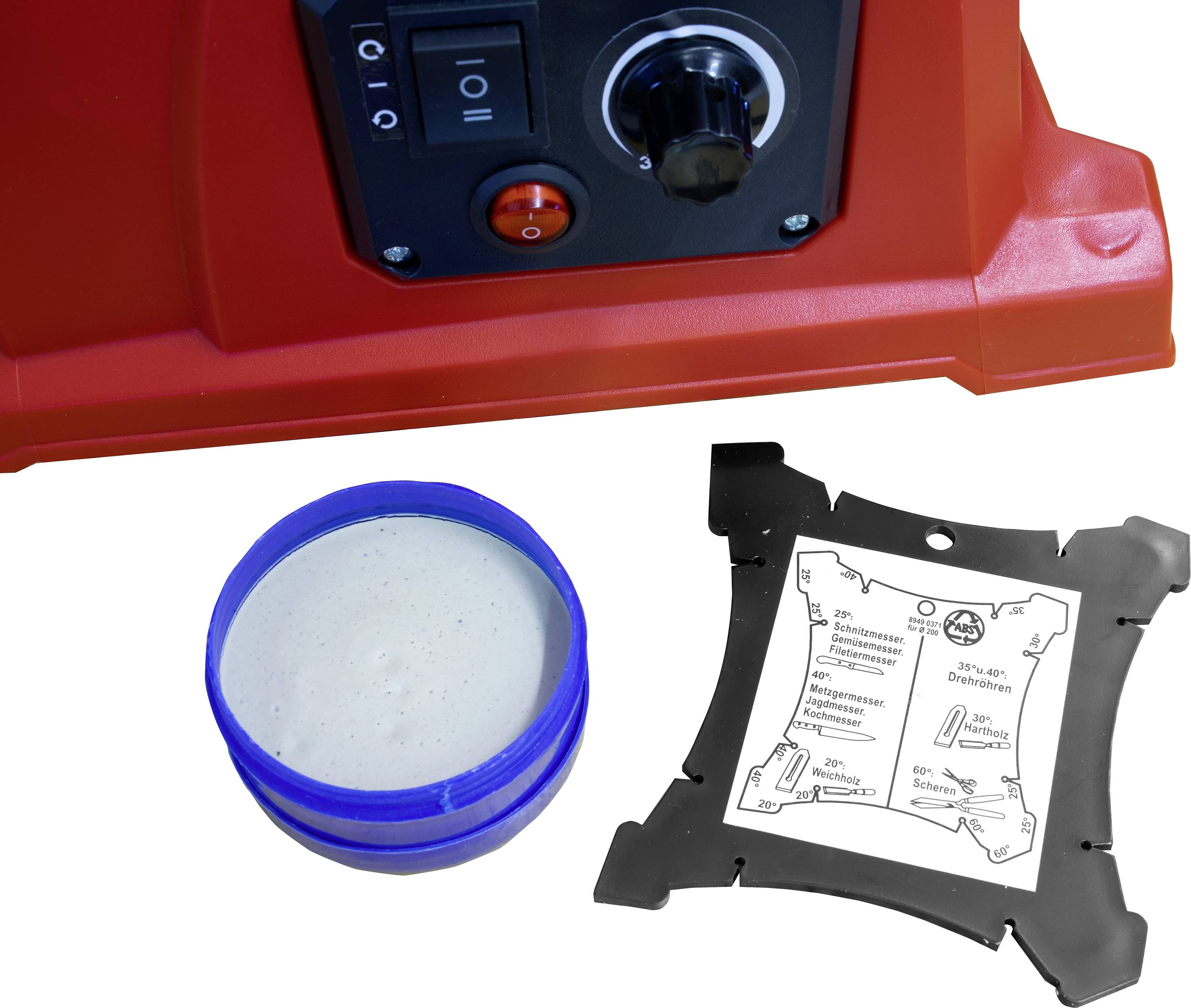 A red machine with switches and buttons, next to a tin of grey paste and a square diagram with instructions.