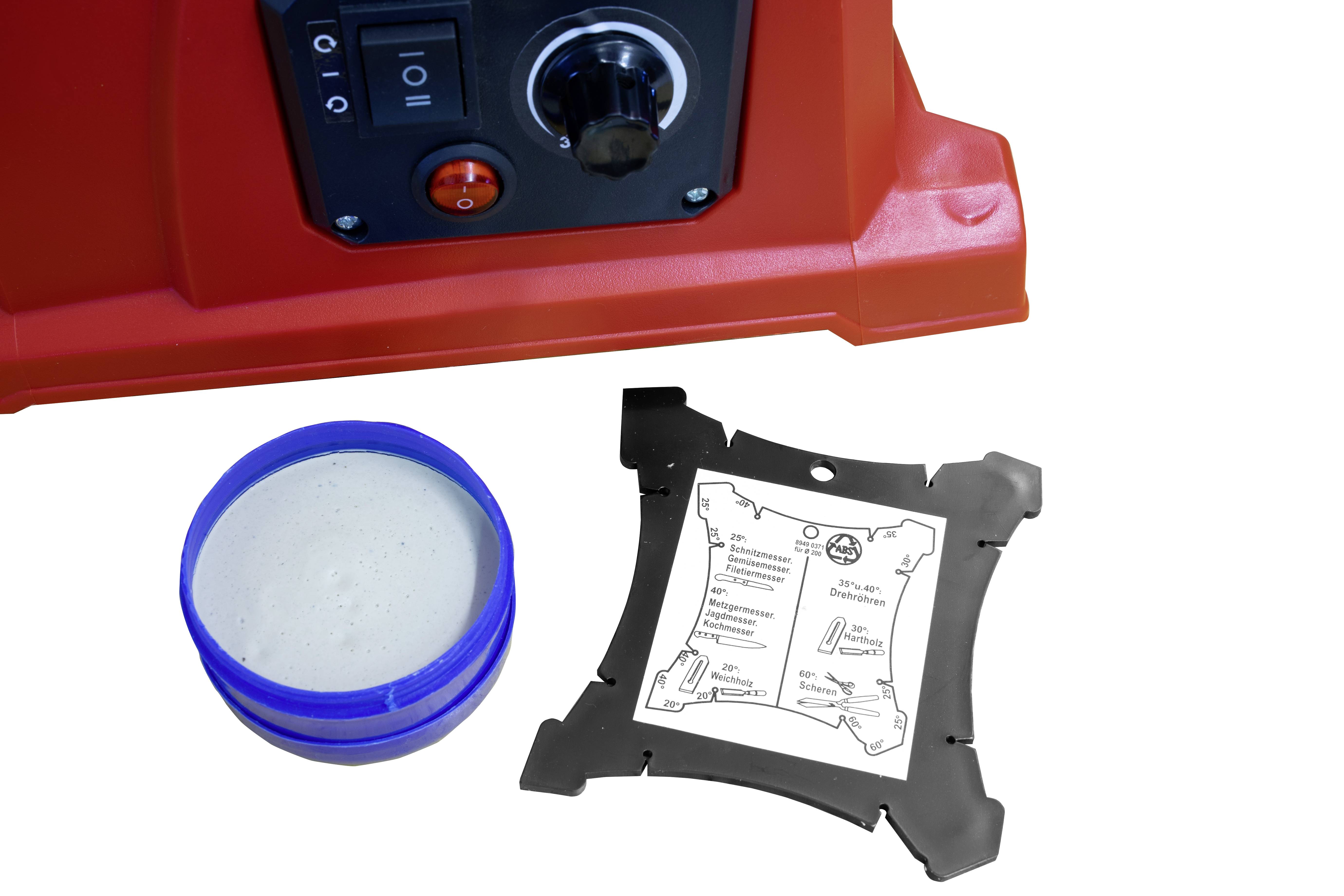 'Red switch with rotary knob and toggle switch, next to blue container with grey contents and black frame with labelling.'