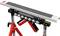 A portable, height-adjustable roller stand with multiple rollers and a sturdy red and black metal frame. Ideal for securely supporting long materials.