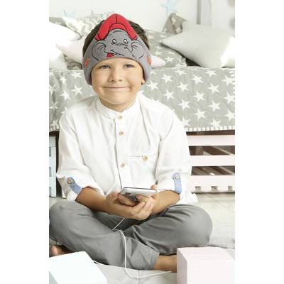 A smiling child with headphones sits on the floor, holding a smartphone. In the background, a bed with a star-patterned design.