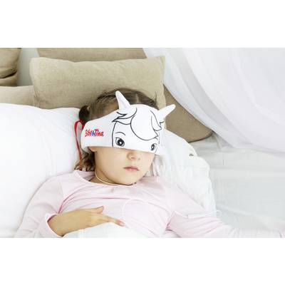 A child lies in bed wearing a cartoon animal-style eye mask connected to a cable. They look relaxed.