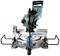 Electric mitre saw with blue handle and transparent guard, positioned on a metal table with scale.