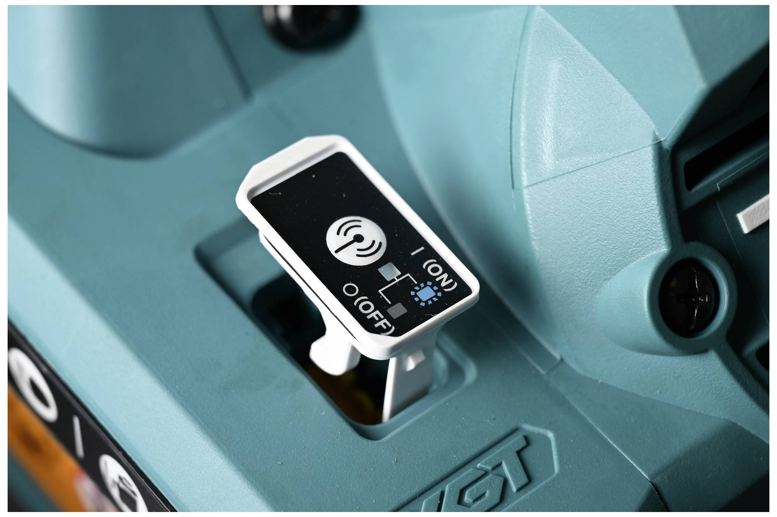 Switch of a machine in the 'OFF' position, displaying a symbol for wireless connectivity. Device surface in teal.