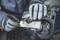 A person wearing work gloves is using a screwdriver to adjust a metal machine on a workbench.