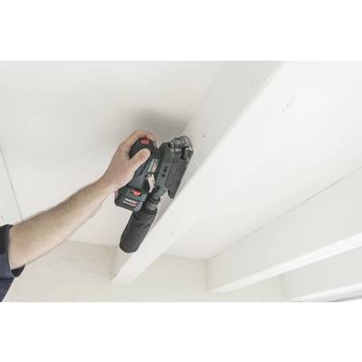A person is sanding a wooden beam ceiling with an electric sanding machine. White beams are visible.