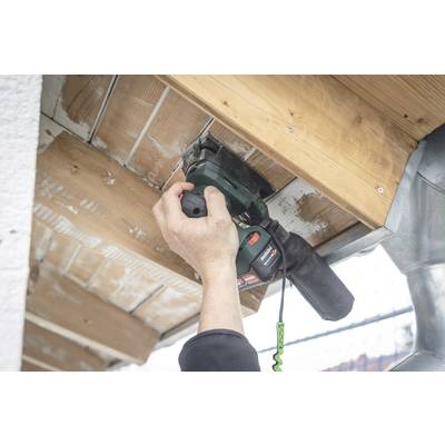 A person is sanding wooden planks with an electric sanding device. The planks are secured to a structure.