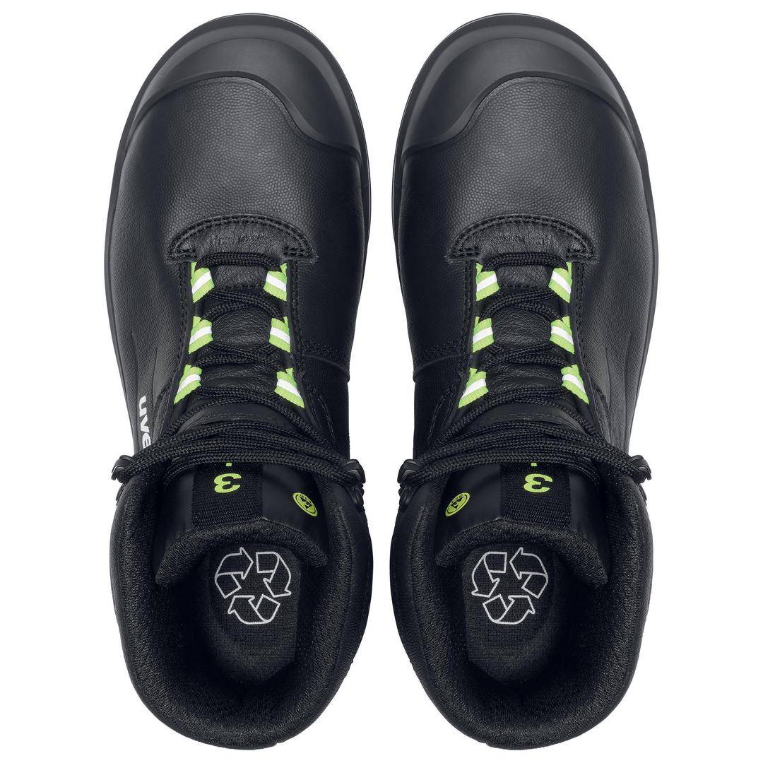 Black, sturdy work shoes with green lace accents made from recycled material. Recycling symbol visible in the soles.