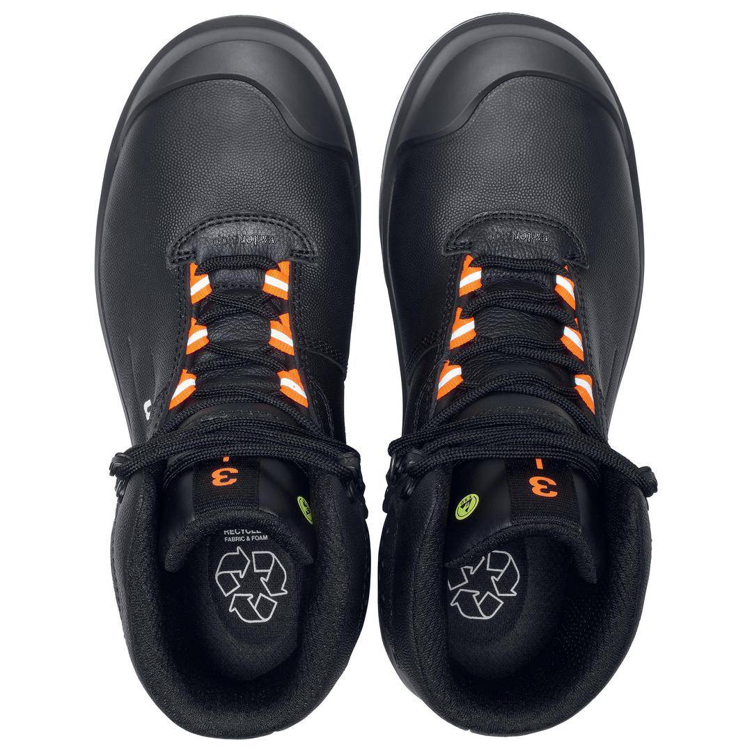 Black boots with orange details, made from recyclable material, photographed from above.