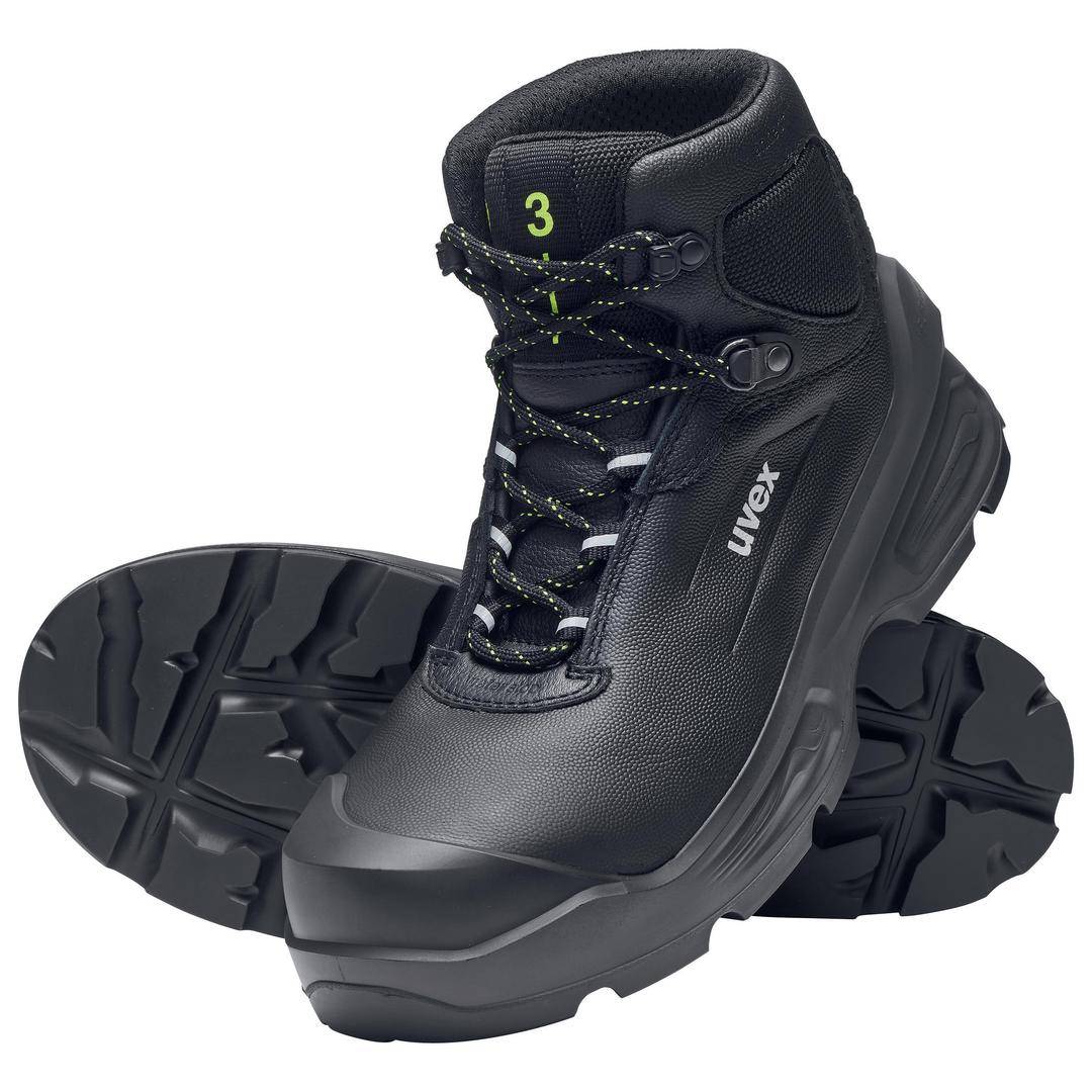 Black safety boots with a thick profiled sole and laces. One boot is standing upright, the other lying sideways in front of it.