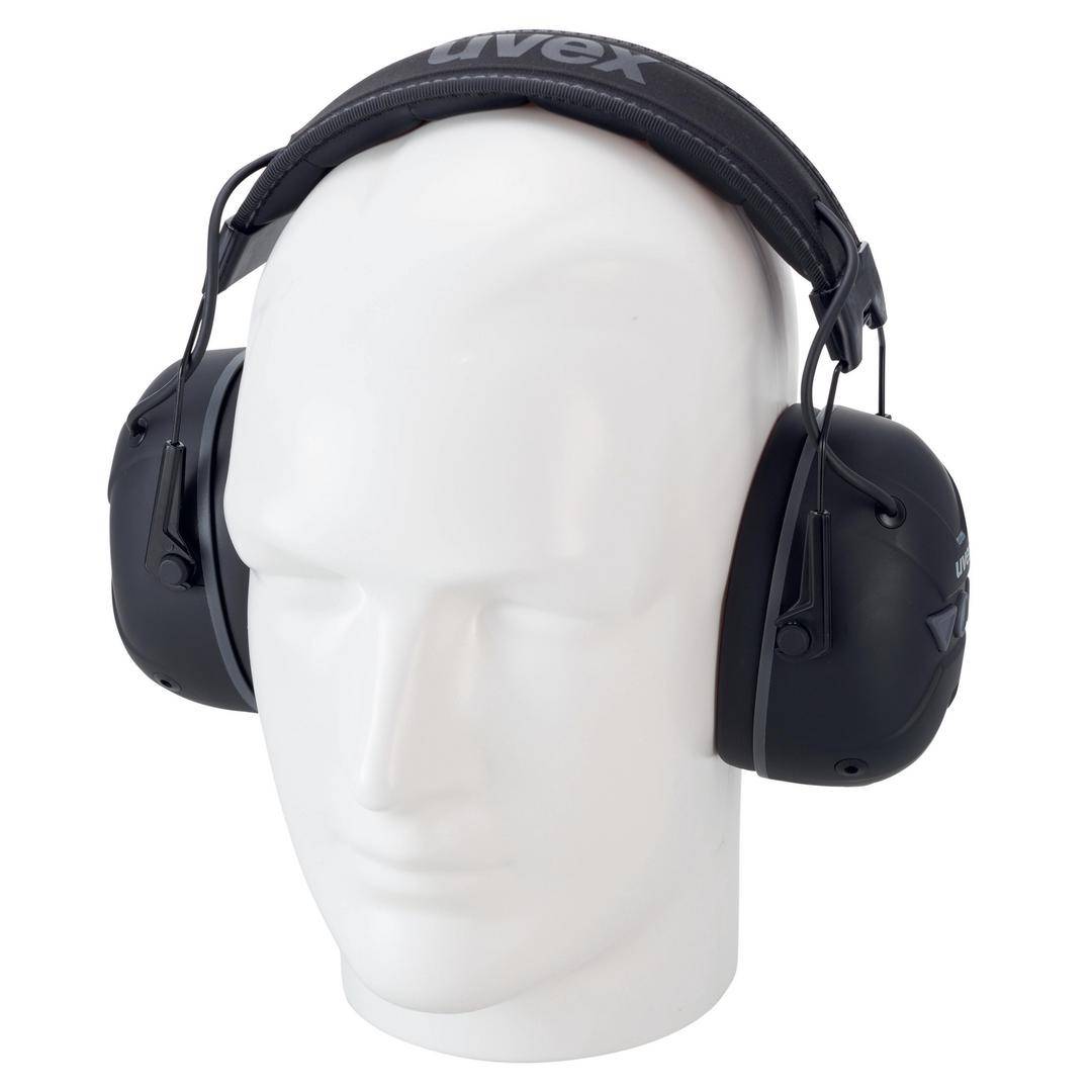 A white mannequin is wearing black ear defenders.