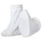 Two white fabric overshoes, one standing upright and the other lying on its side. They are simply and functionally designed.