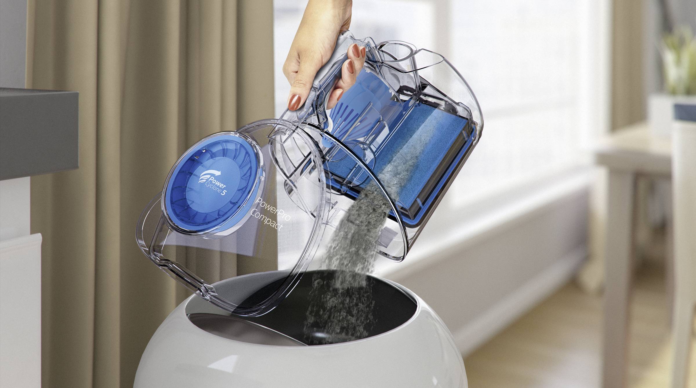 'A hand empties the dust container of a cordless vacuum cleaner over a rubbish bin. The dust falls into the open container.'