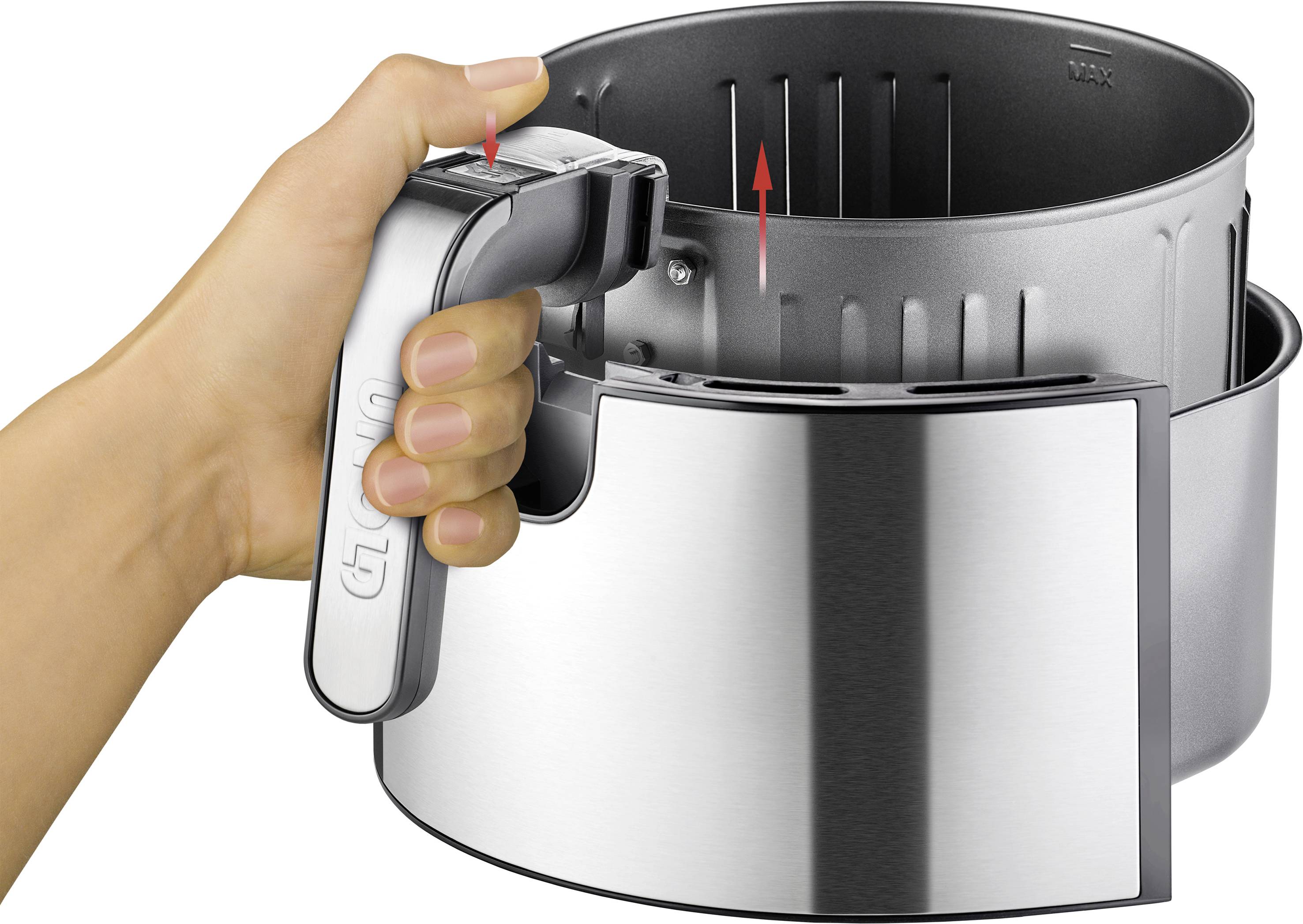 A hand grips the handle of a metal basket, which is being lifted into a gleaming silver bowl. A red arrow indicates the movement.