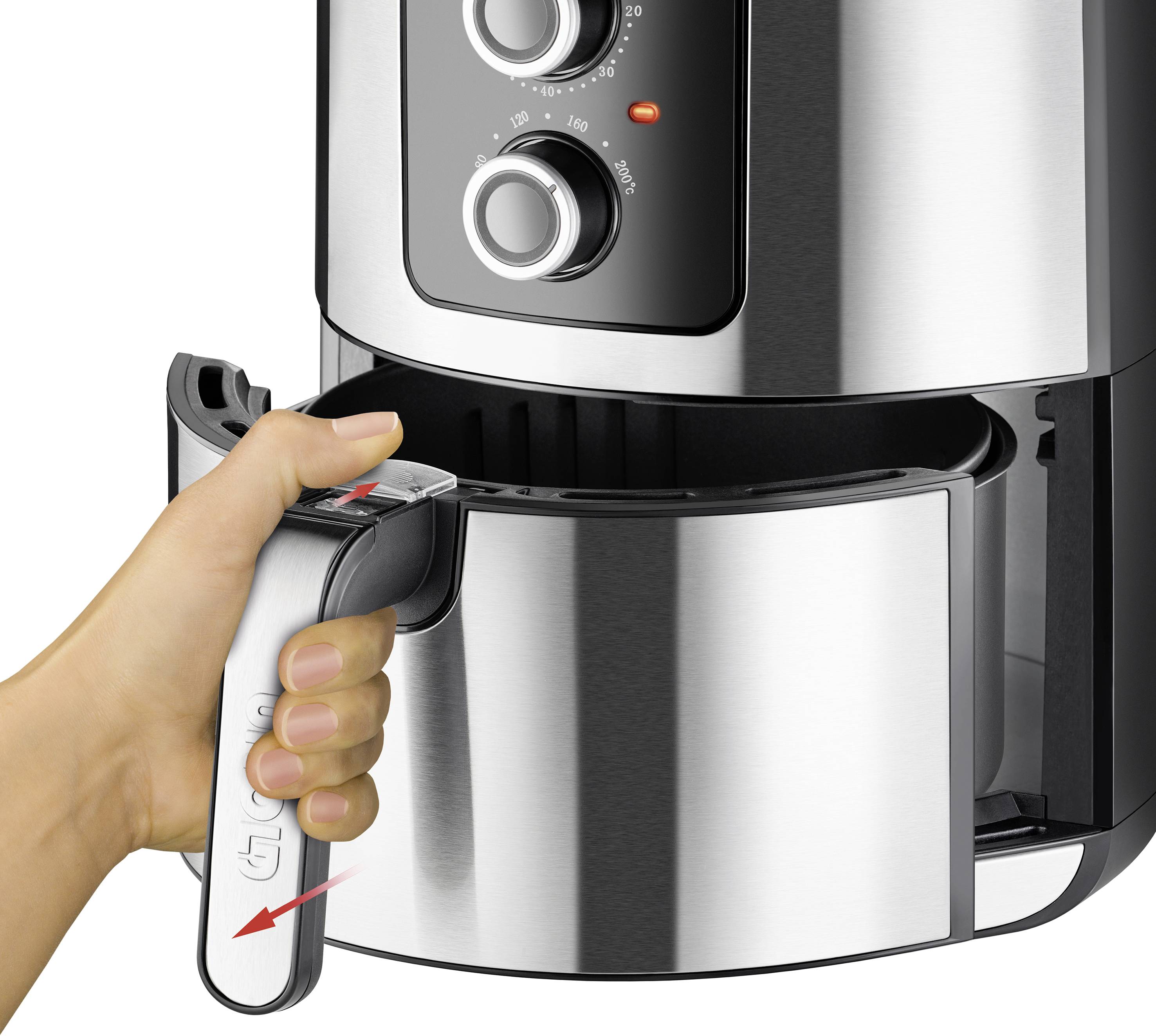 A hand pulls out the basket of a modern air fryer. The air fryer has two rotary knobs for temperature control.