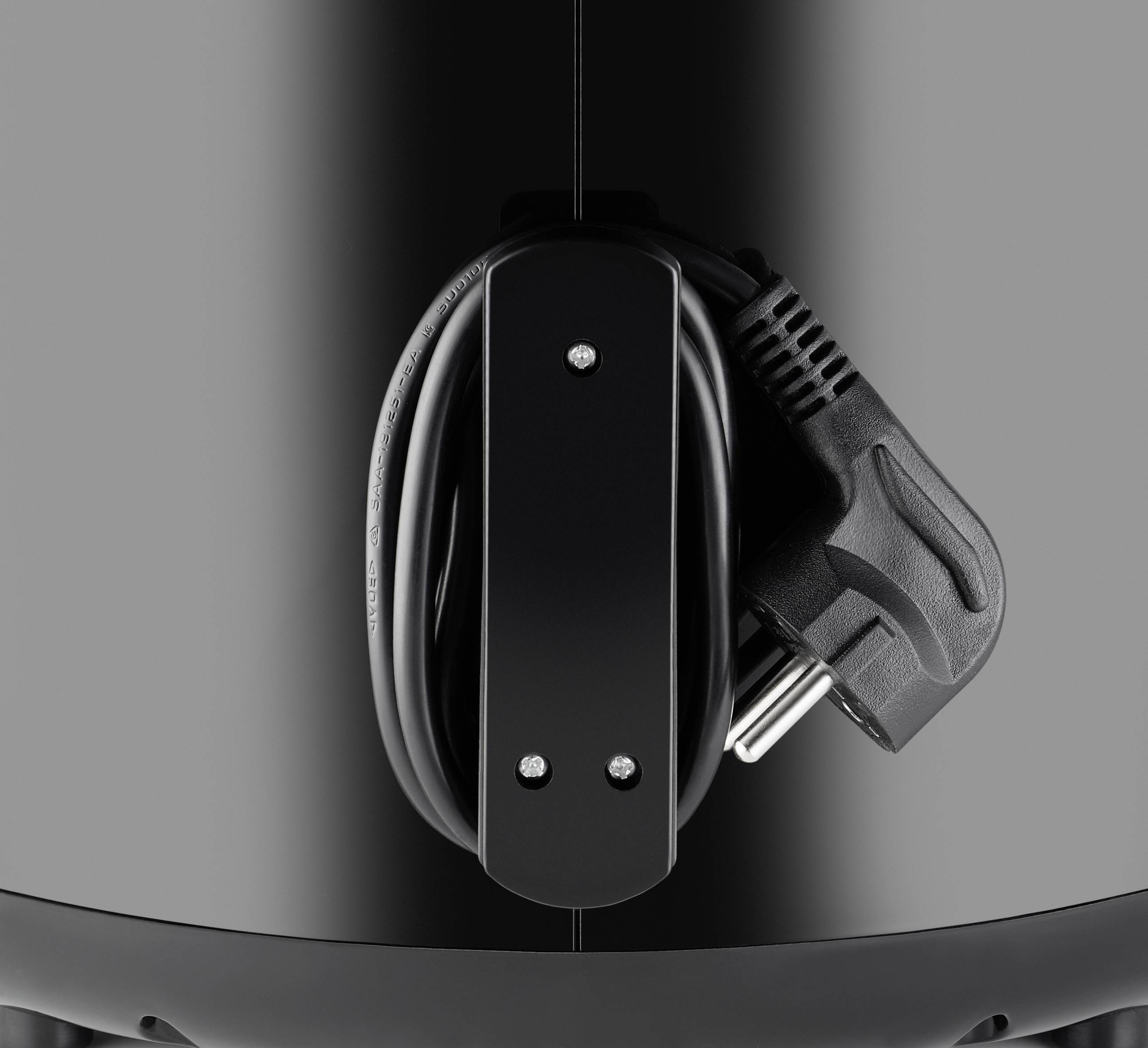 A black vacuum cleaner is visible, with a cable neatly coiled around its cable holder.