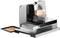 An electric bread slicing machine with sausage slices on a catching tray. The device is made of metal and plastic.