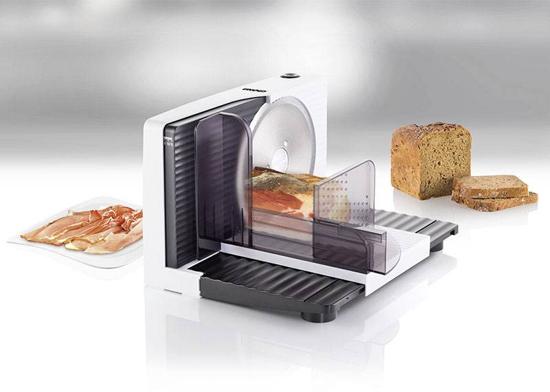 Electric all-purpose slicers on a white background, cutting bread, sausage, and cheese. Accompanying accessories are placed beside them.