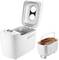 White bread maker with an open lid and a removable baking tin, containing a freshly baked loaf of bread.