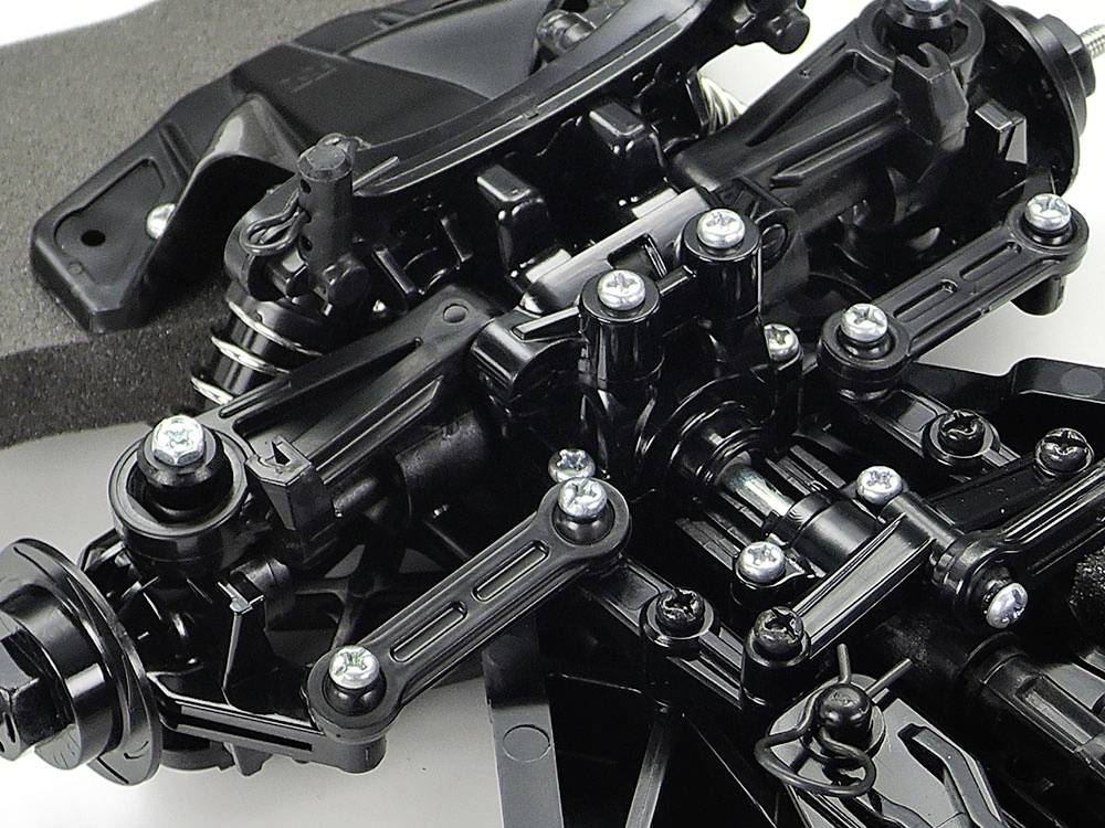 Close-up of a complex black mechanical component with silver-coloured screws and connections, potentially part of a vehicle or model.