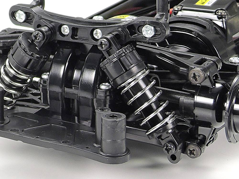 Suspension system of a remote-controlled car, showing springs, suspension and shock absorbers, against a light background.