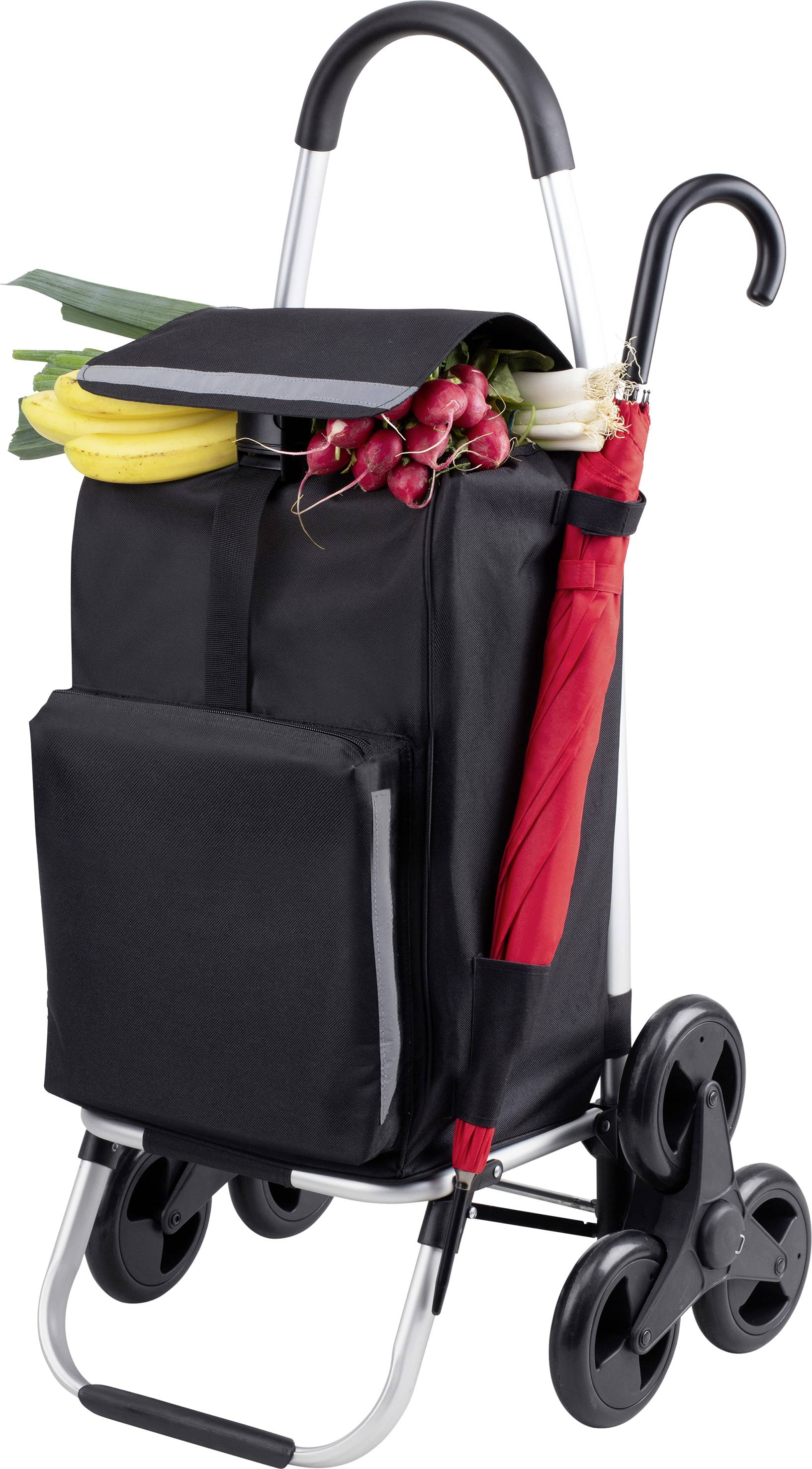 A black shopping trolley with red handles, filled with bananas, radishes and leeks, next to a folded red umbrella.