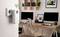 A Wi-Fi adapter is plugged into a socket and is boosting the signal in a modern home office with two monitors.