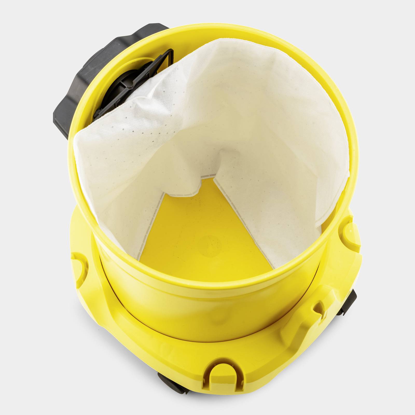 Top view of an open yellow industrial vacuum cleaner showing the white dust filter inside.