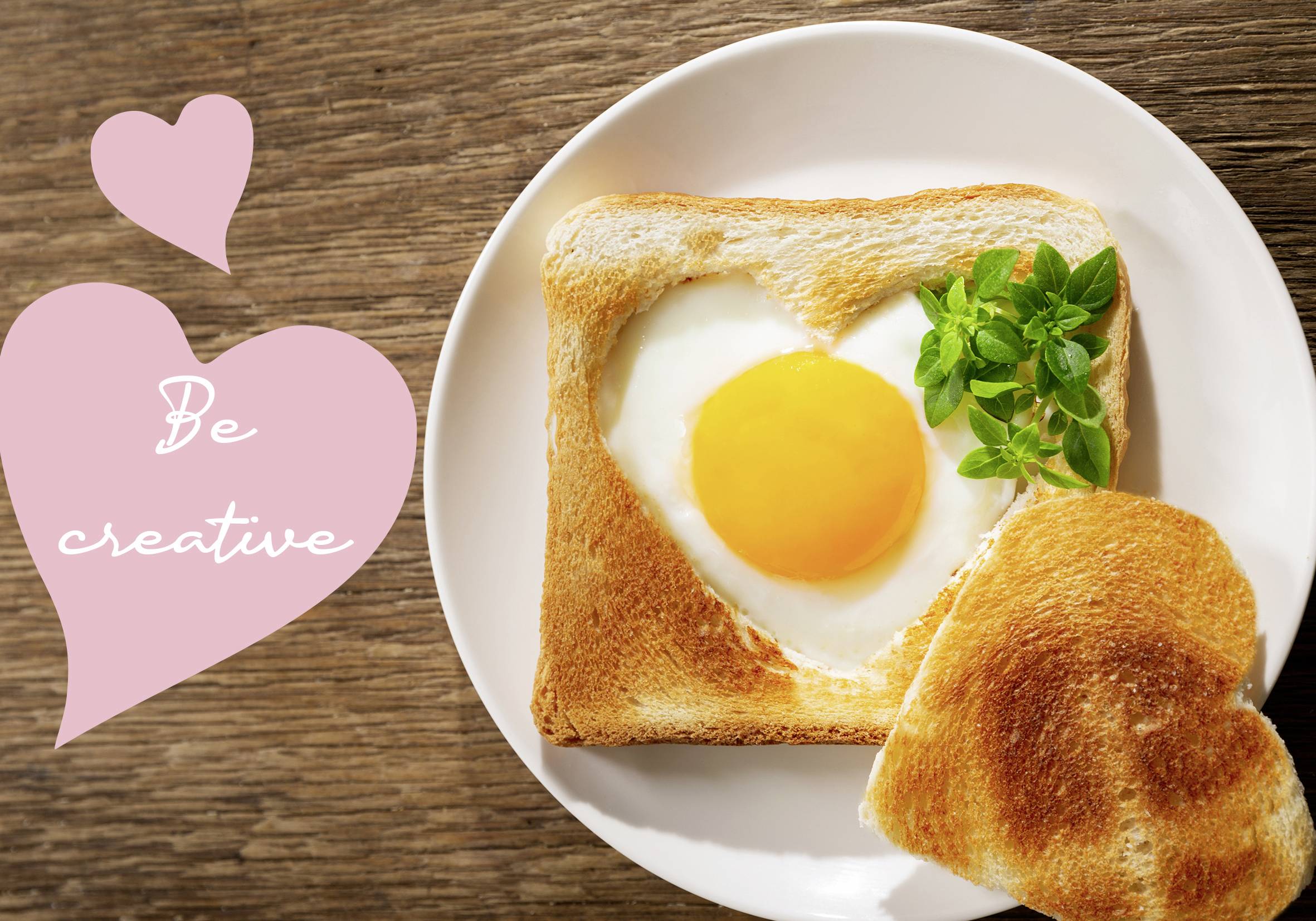 A slice of toast with a heart-shaped fried egg and herbs on a plate. To the left, a heart with the text 'Be creative'.