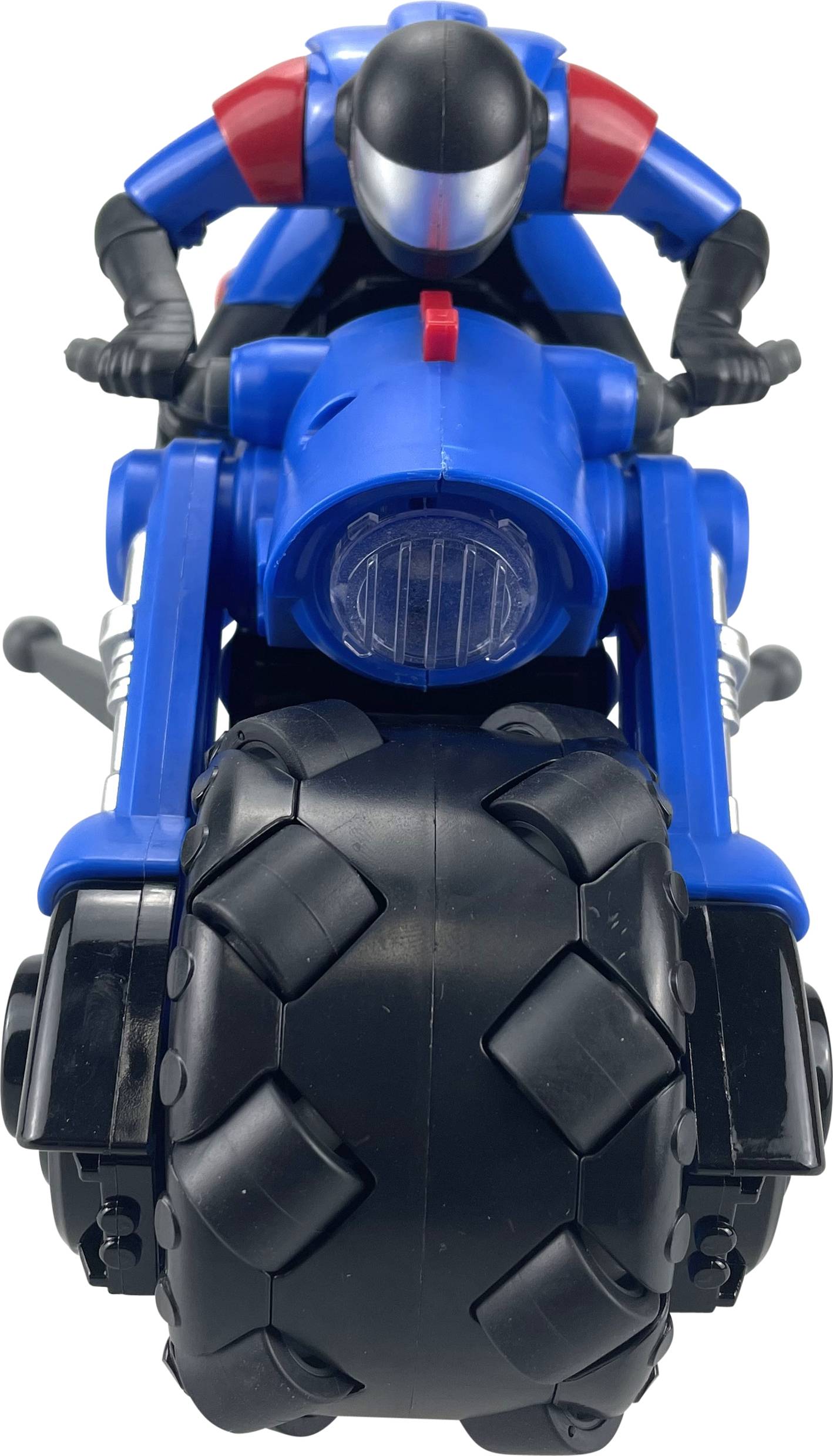 A toy figure on a blue motorbike with thick black tyres, sitting in a racing position on the vehicle.