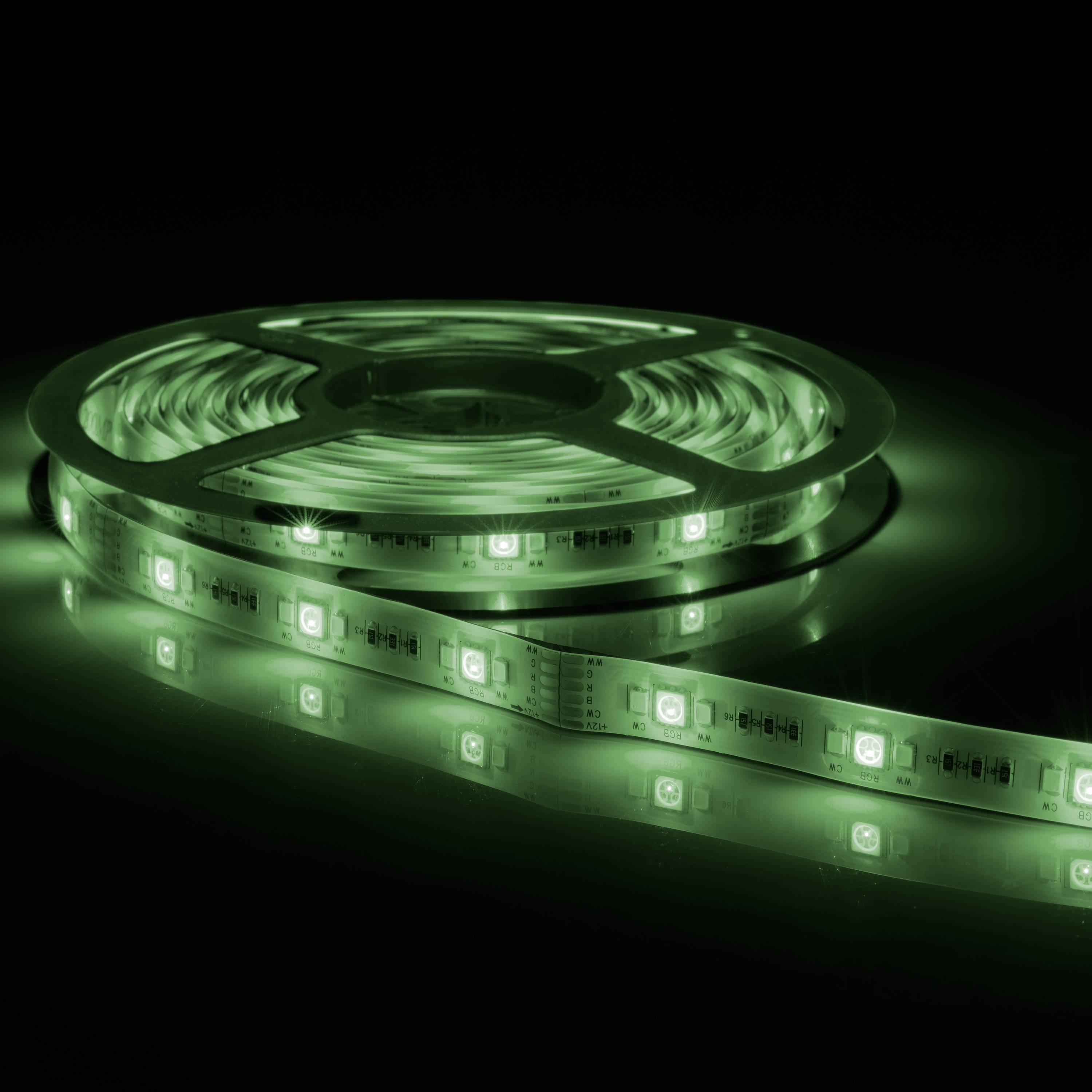 Green LED light strip, wound on a reel, illuminating an area in a dark environment.