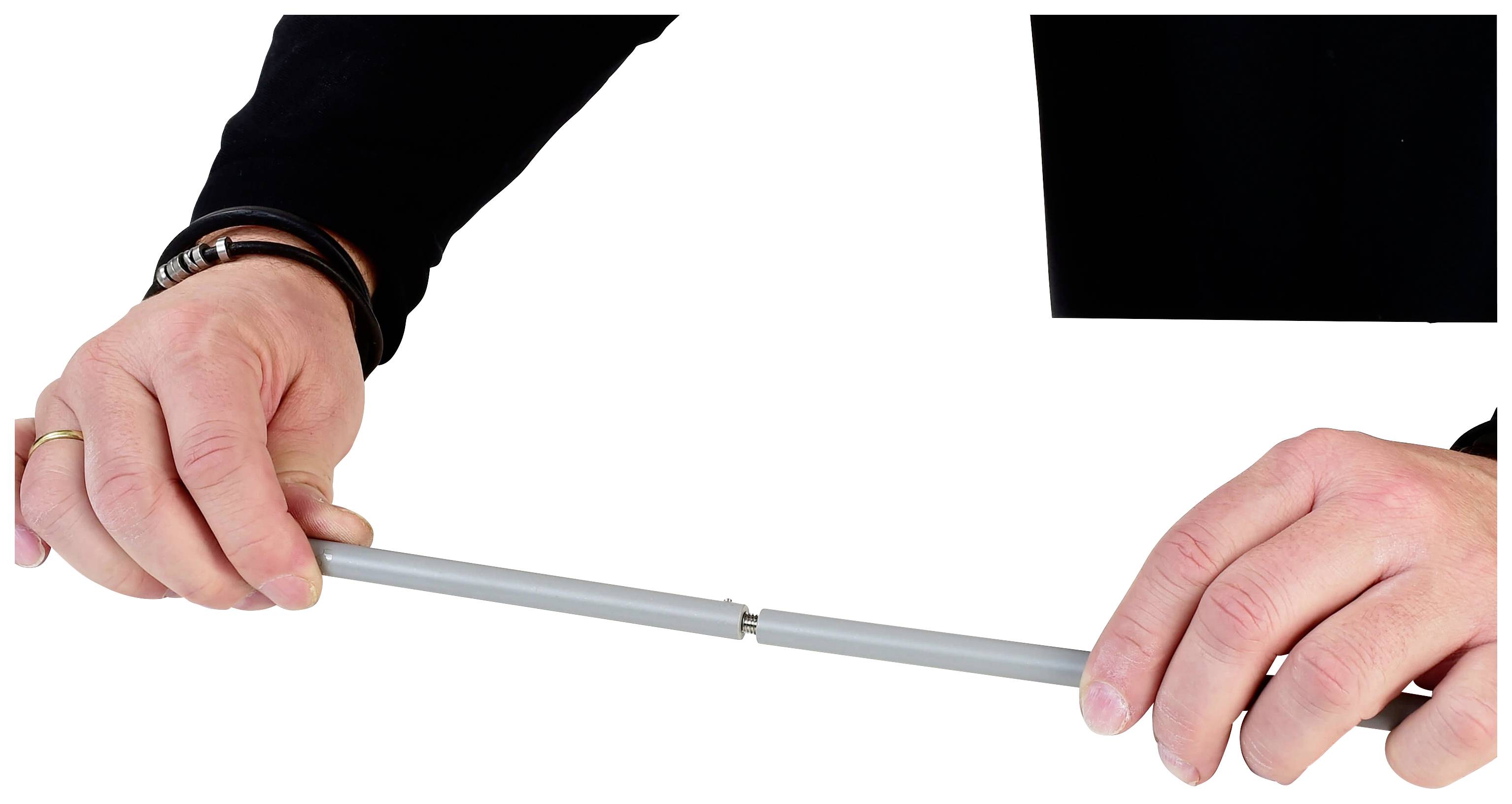 'Two hands are holding a grey, modular interlocking pipe.'