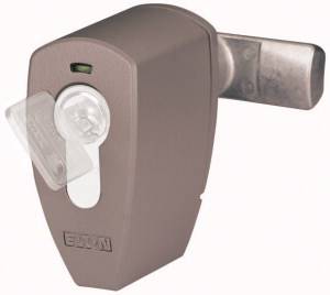 Brown door lock with a transparent plastic shield and a key in the keyhole, mounted on a metal bar.