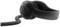 Black headphones with padded over-ear headband and coiled cable, lying on a white background.