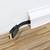 A black HDMI cable is routed through the wooden parquet floor beneath a white skirting board.