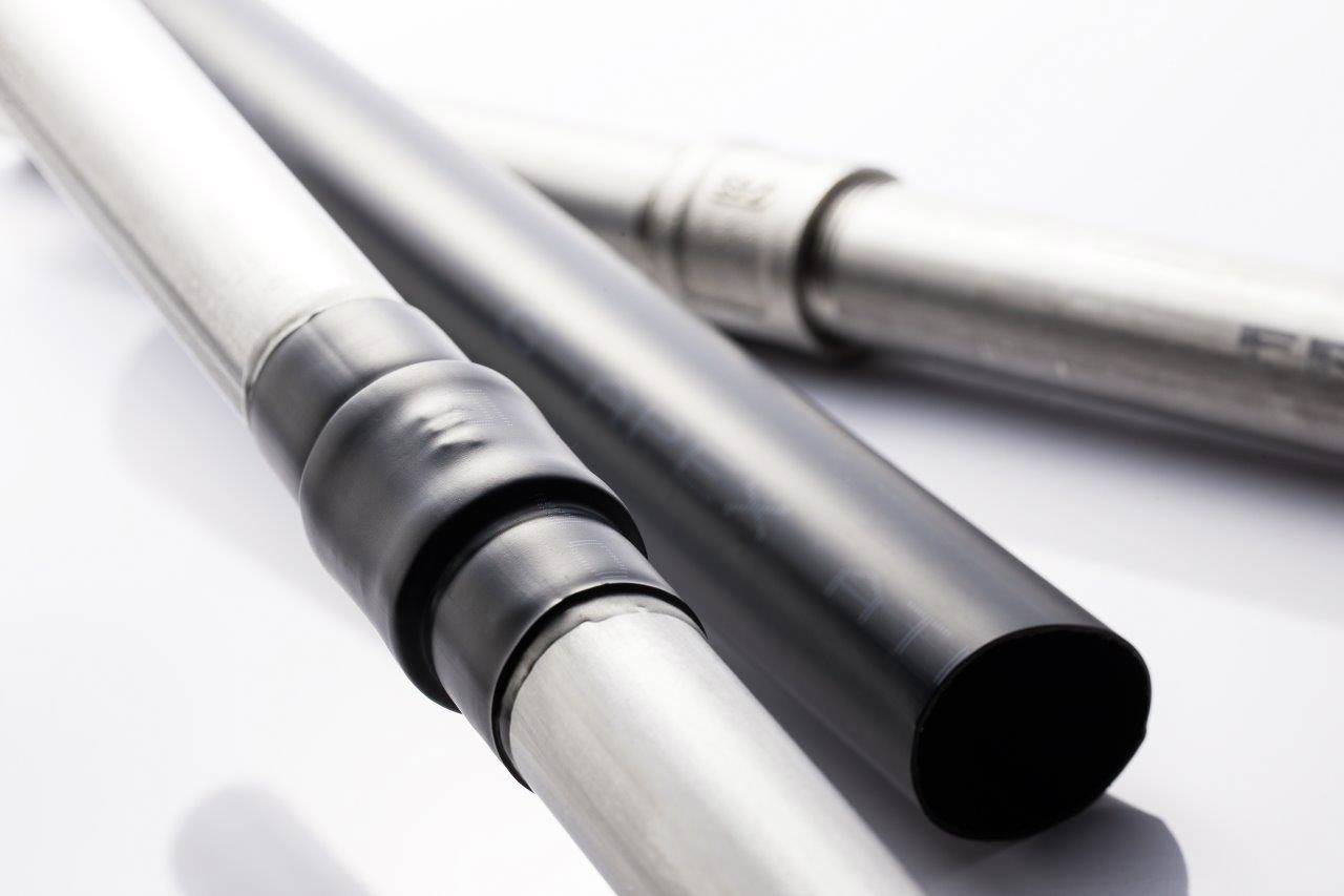 Three metal tubes: one is black-coated, the others are silver. They are lying diagonally on a white background.
