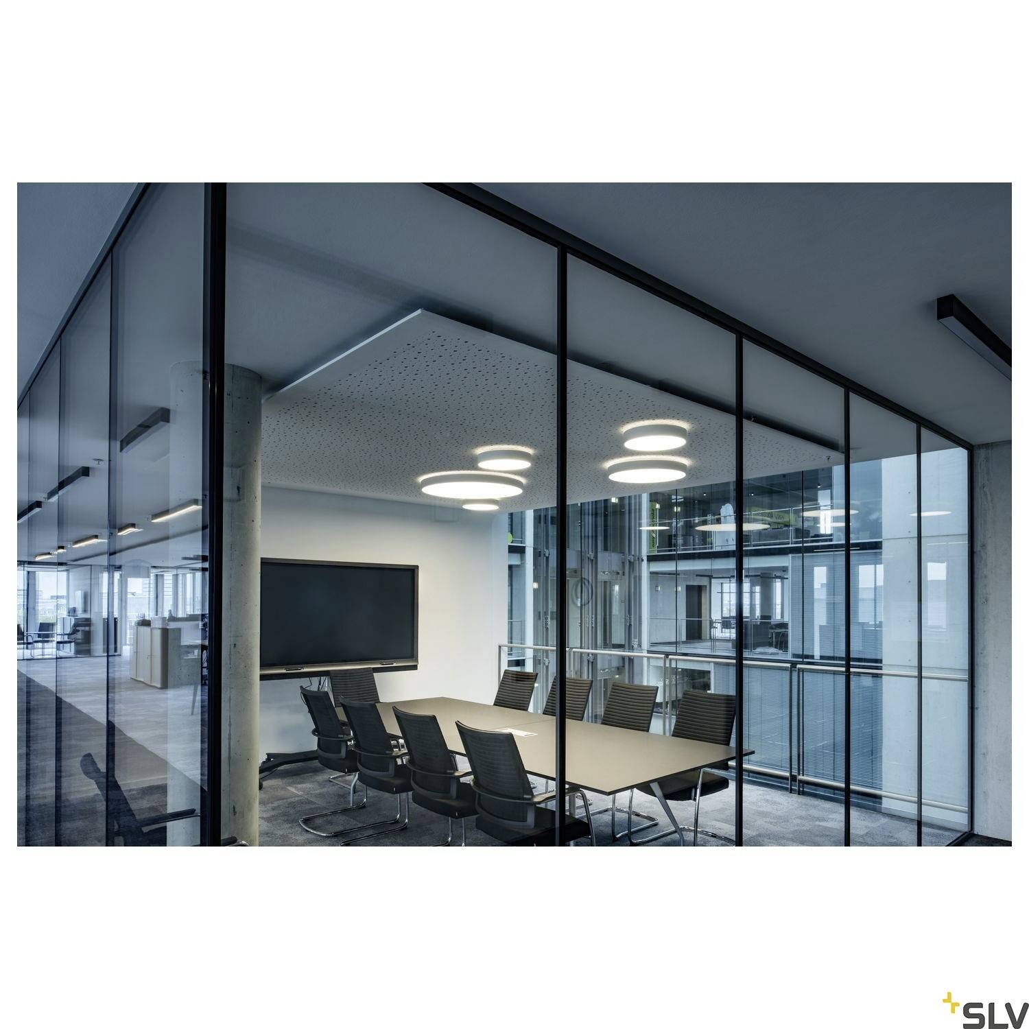 Conference room with glass partition walls, a table with eight chairs, wall-mounted screen, and modern ceiling lighting.