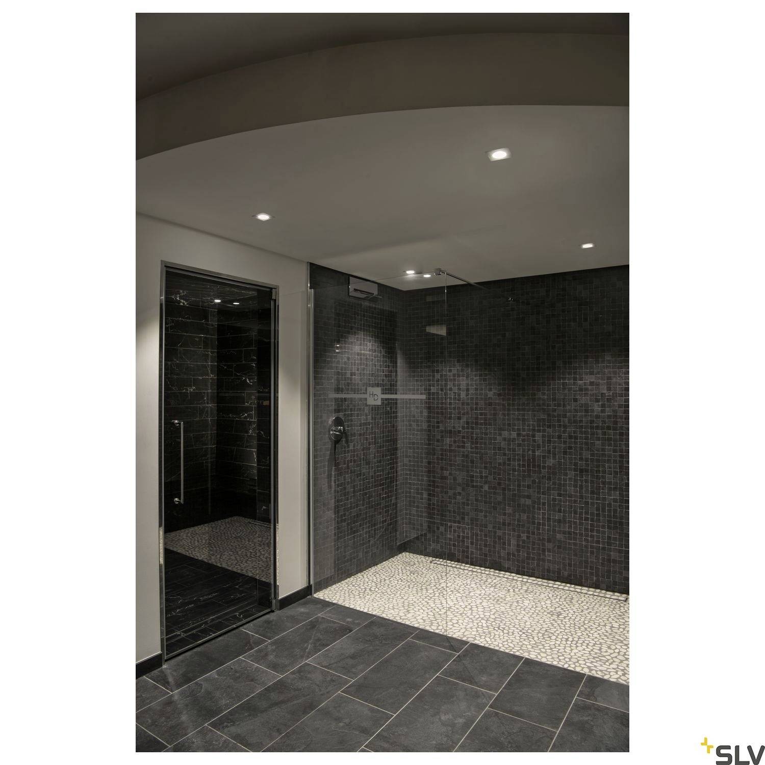 Modern shower room with dark tiles, recessed ceiling spotlights and a walk-in shower with no visible enclosure.