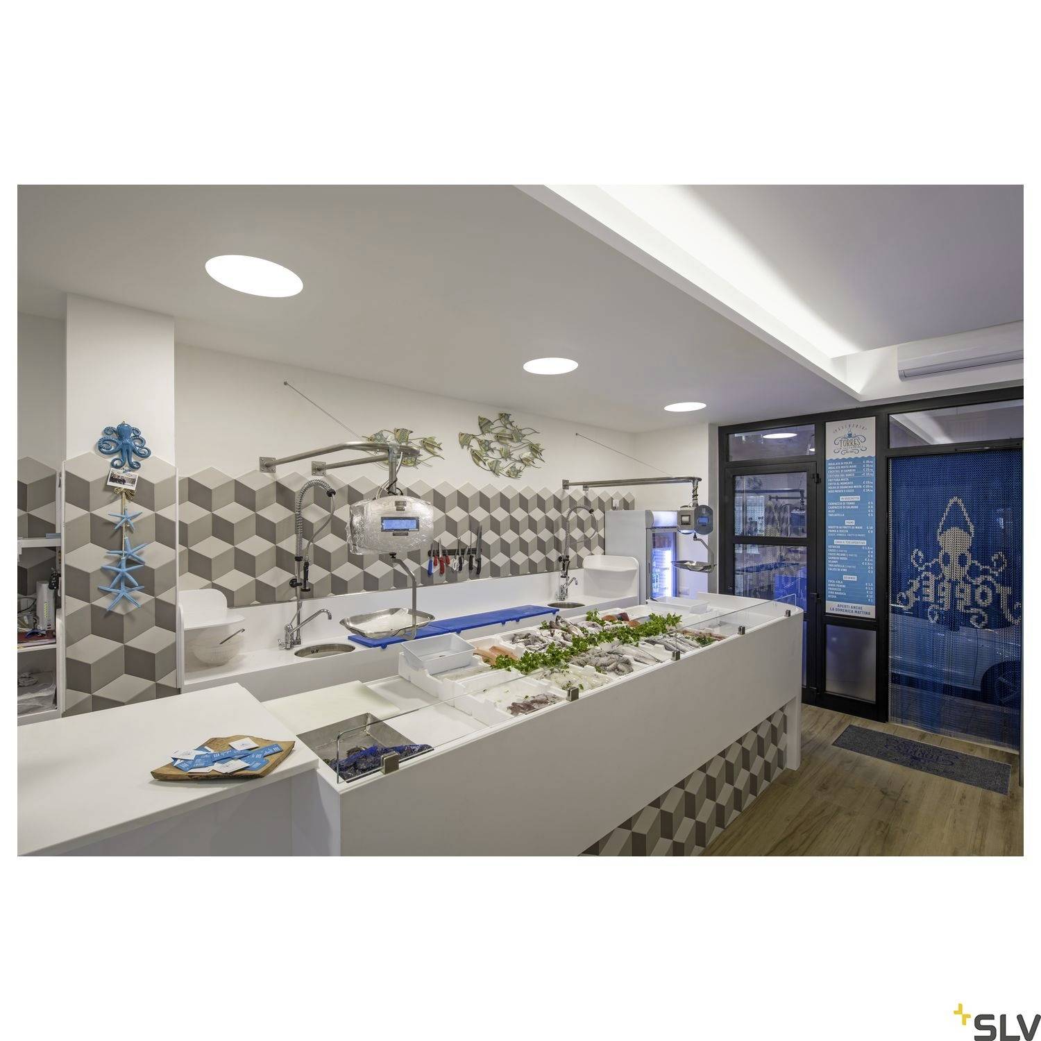 A modern fishmonger's shop with a selection of fresh seafood on ice. Bright lighting and geometric tiles on the wall.