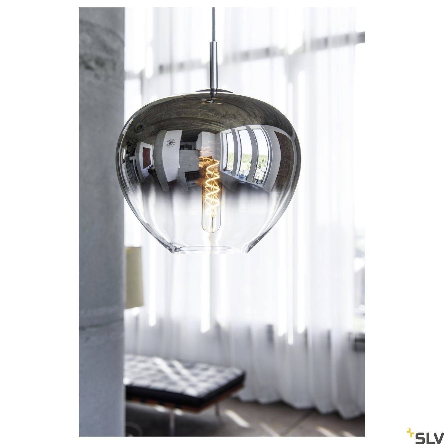 A stylish pendant lamp with a metallic finish and an exposed light bulb illuminates a modern room.