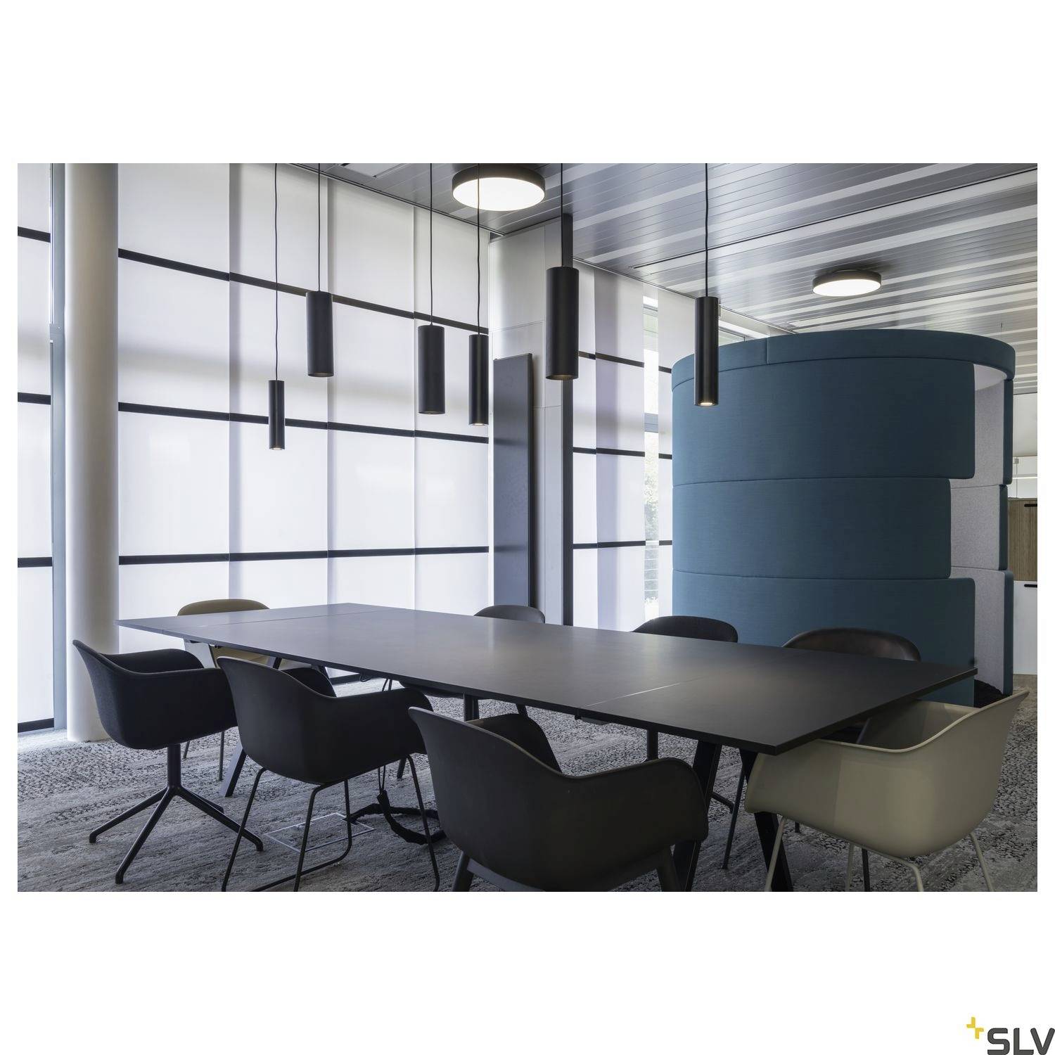 Office with a modern conference table and eight chairs in a well-lit room with large windows and stylish pendant lights.