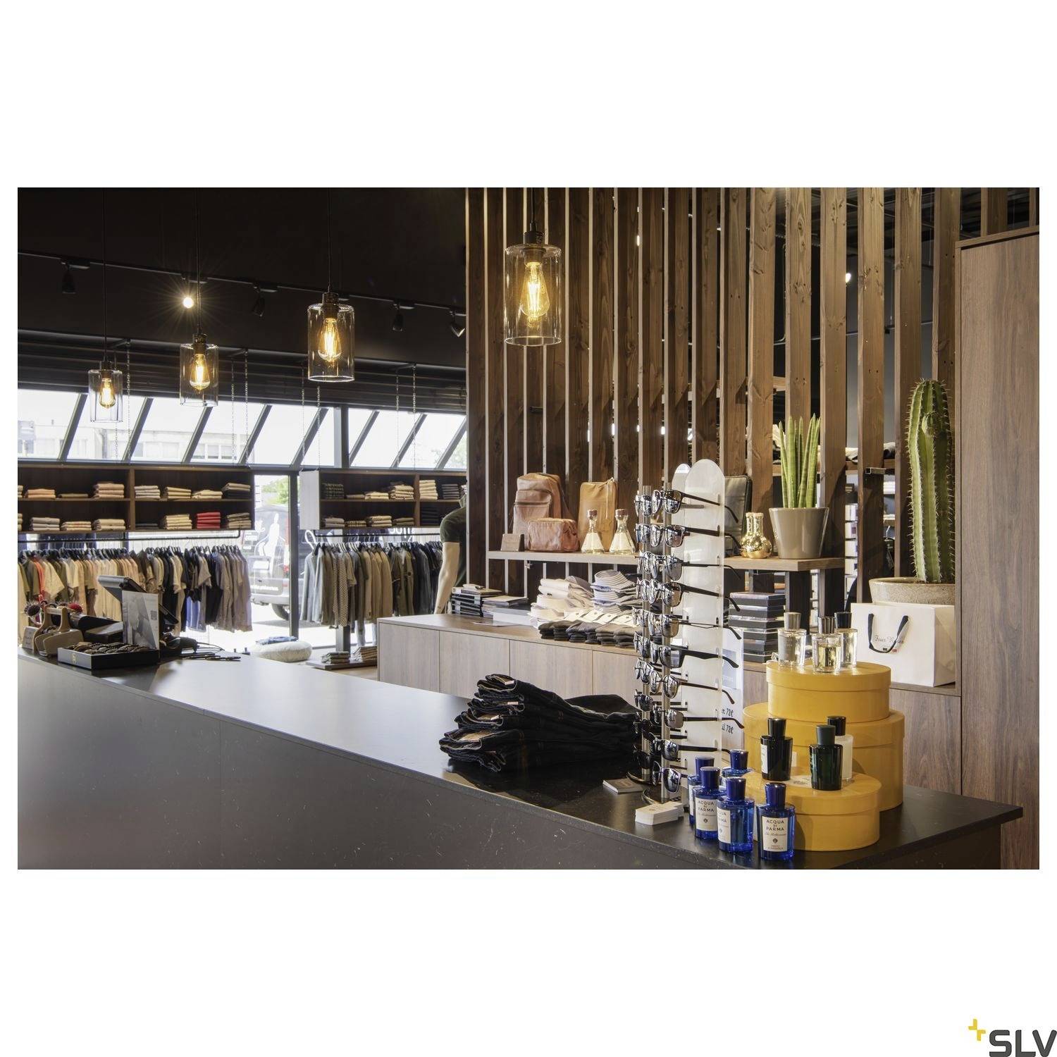A modern clothing store with shelves full of garments and accessories, a long sales counter, and decorative lighting.