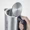 Stainless steel electric kettle with an open lid, with a hand holding the handle.