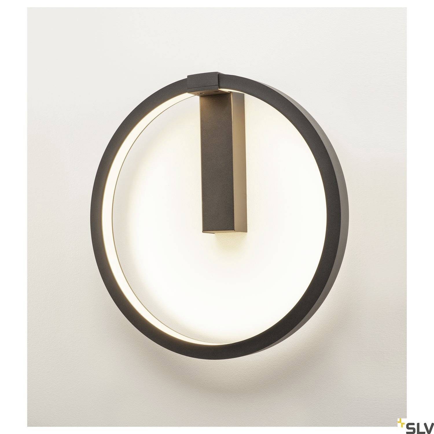 A modern, circular wall light with a black border and a central, rectangular mount. It emits soft light.