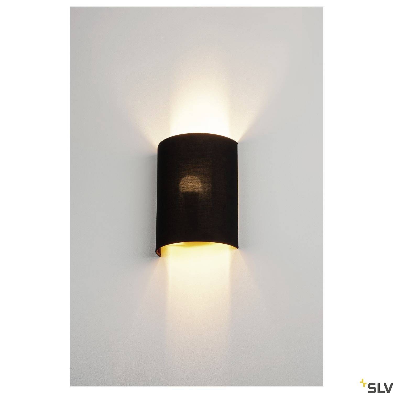 Wall light with a black shade, casting diffused light upwards and downwards, mounted on a white wall.