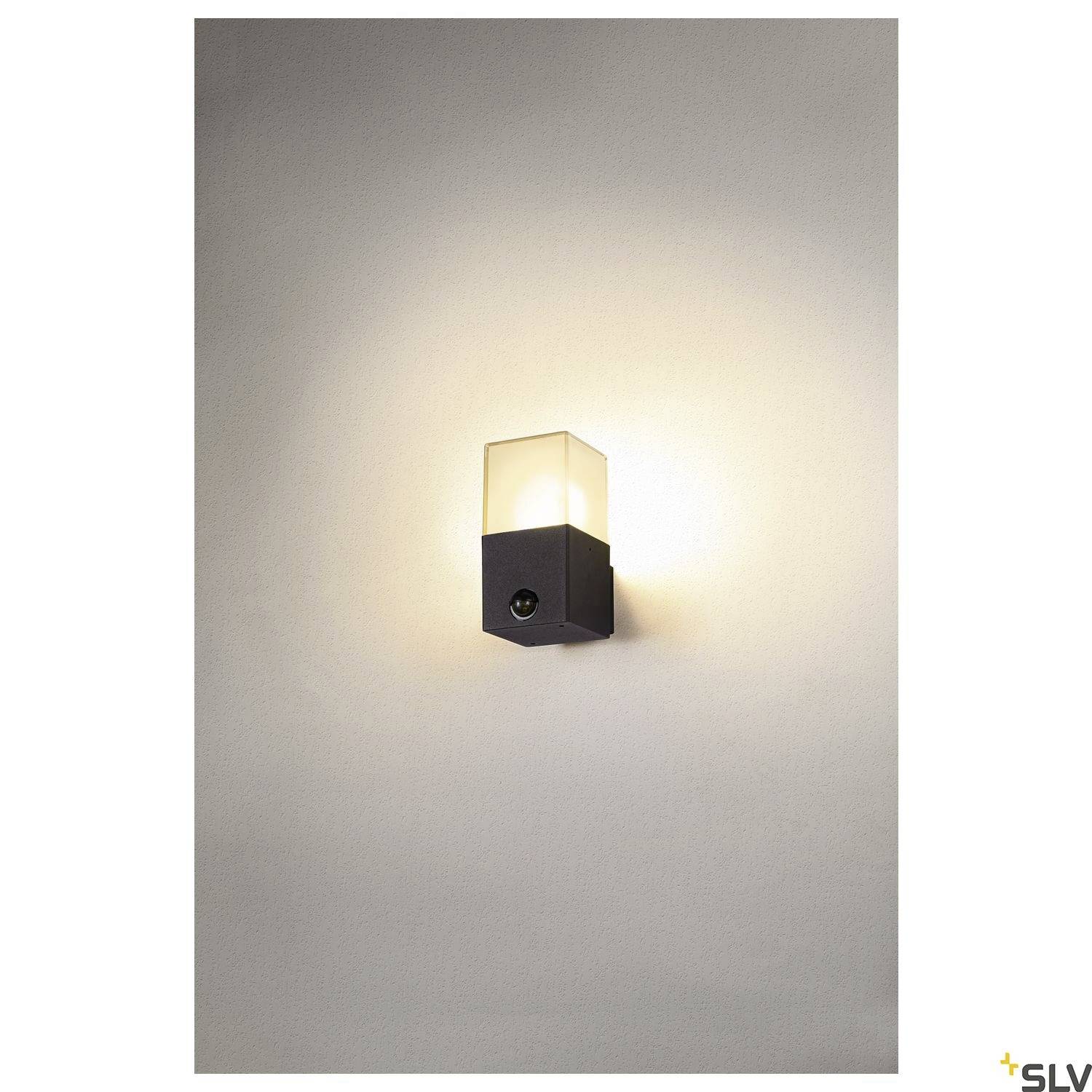 A contemporary wall light with a rectangular, black housing and a glass lampshade that emits warm light.