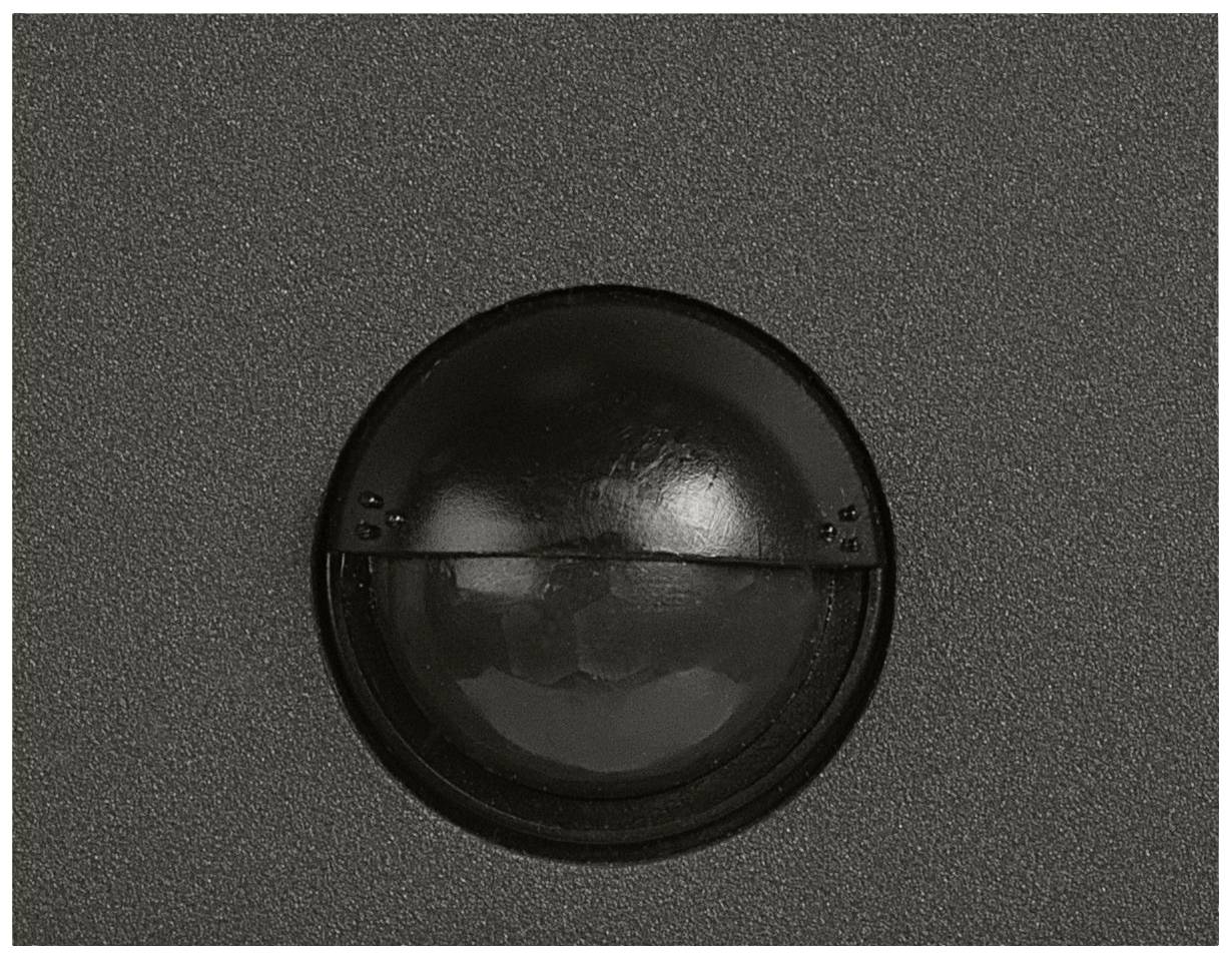 Black round object on a grey background, possibly a dome or lens.