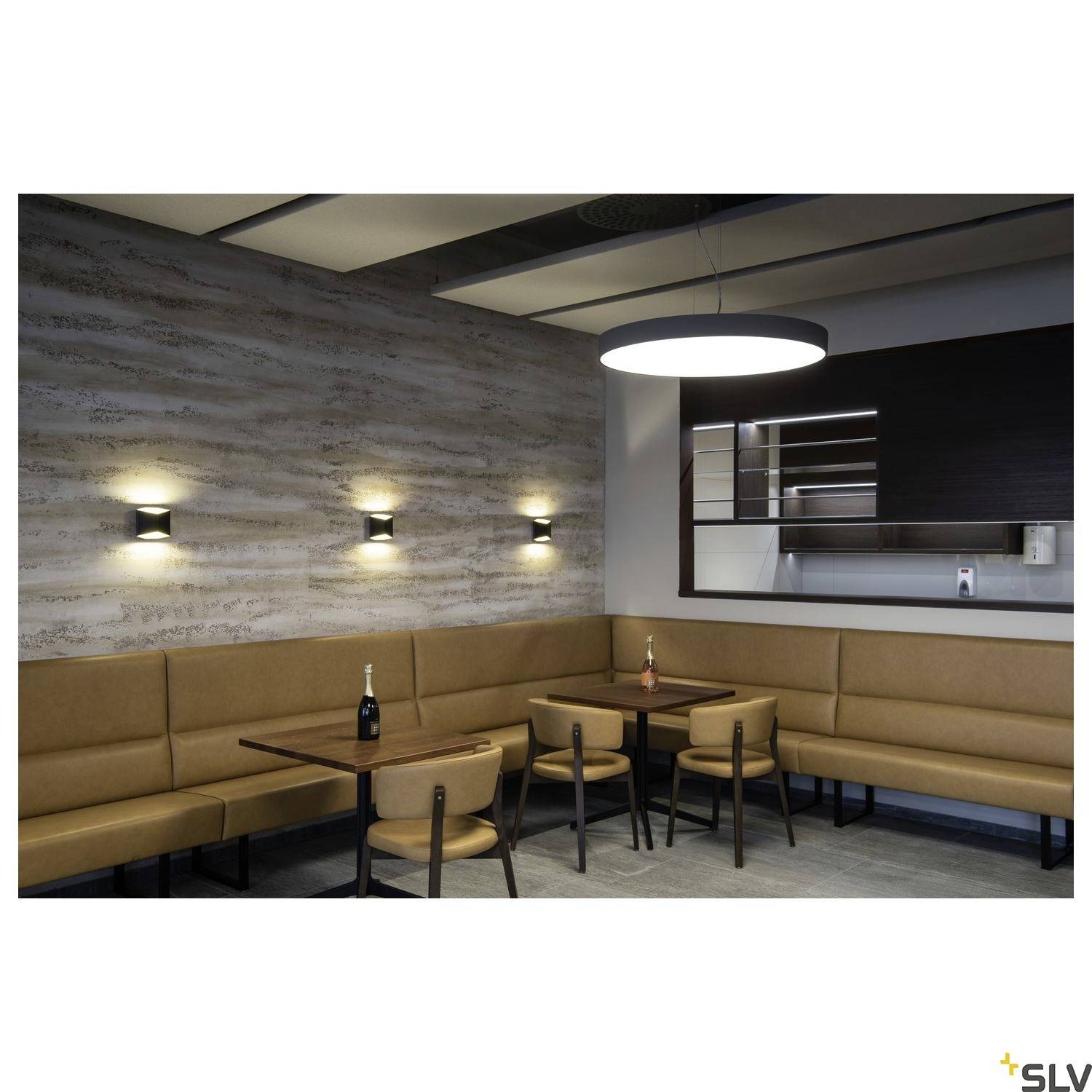 A modern café with minimalist decor, brown seating areas, wooden tables and subtle wall lighting that creates a cosy atmosphere.